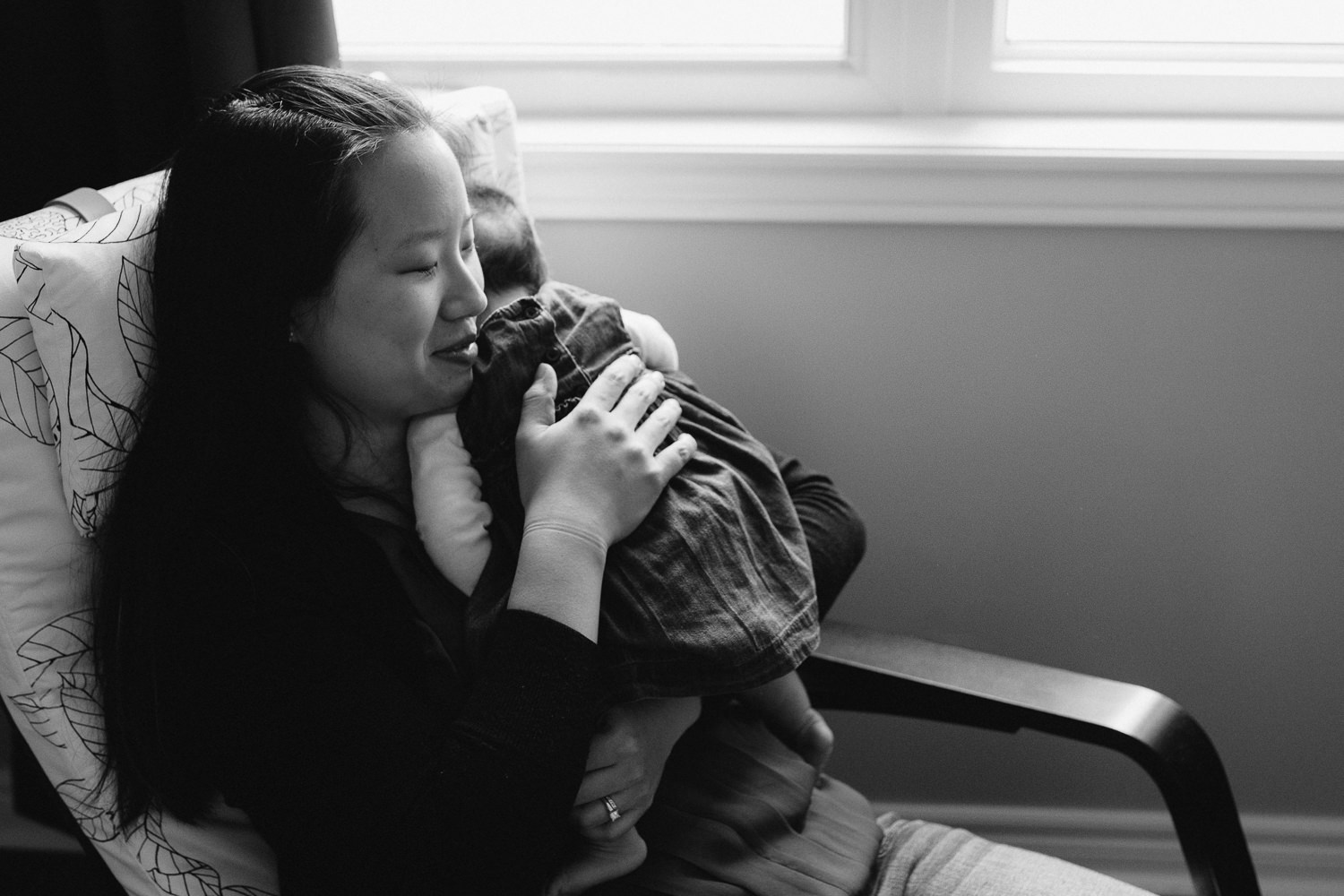 new mom snuggles 2 month old baby daughter to chest - Newmarket In-Home Photography