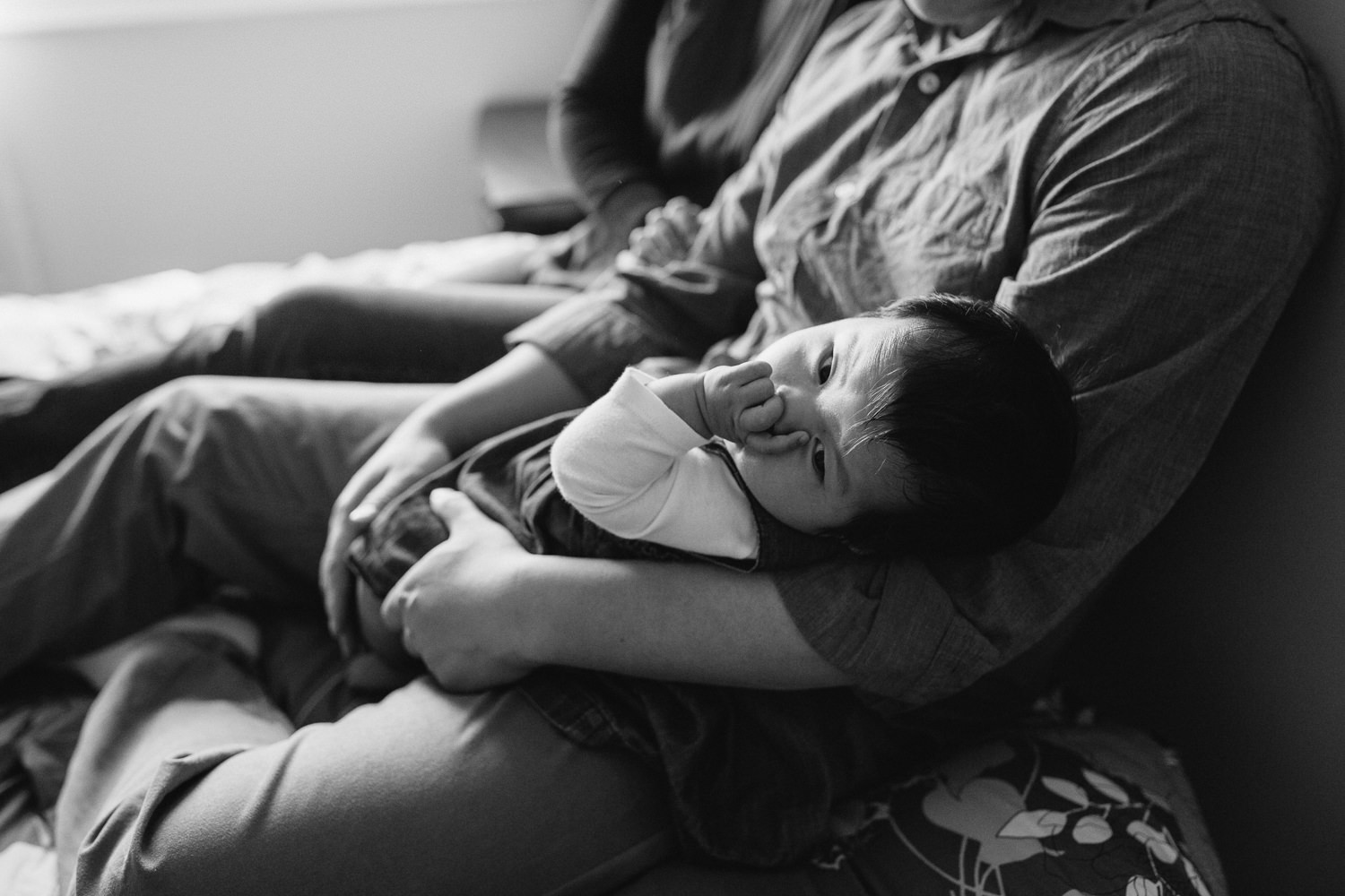 3 month old baby girl in father's arms sucking thumb and looking at camera - Uxbridge Lifestyle Photos