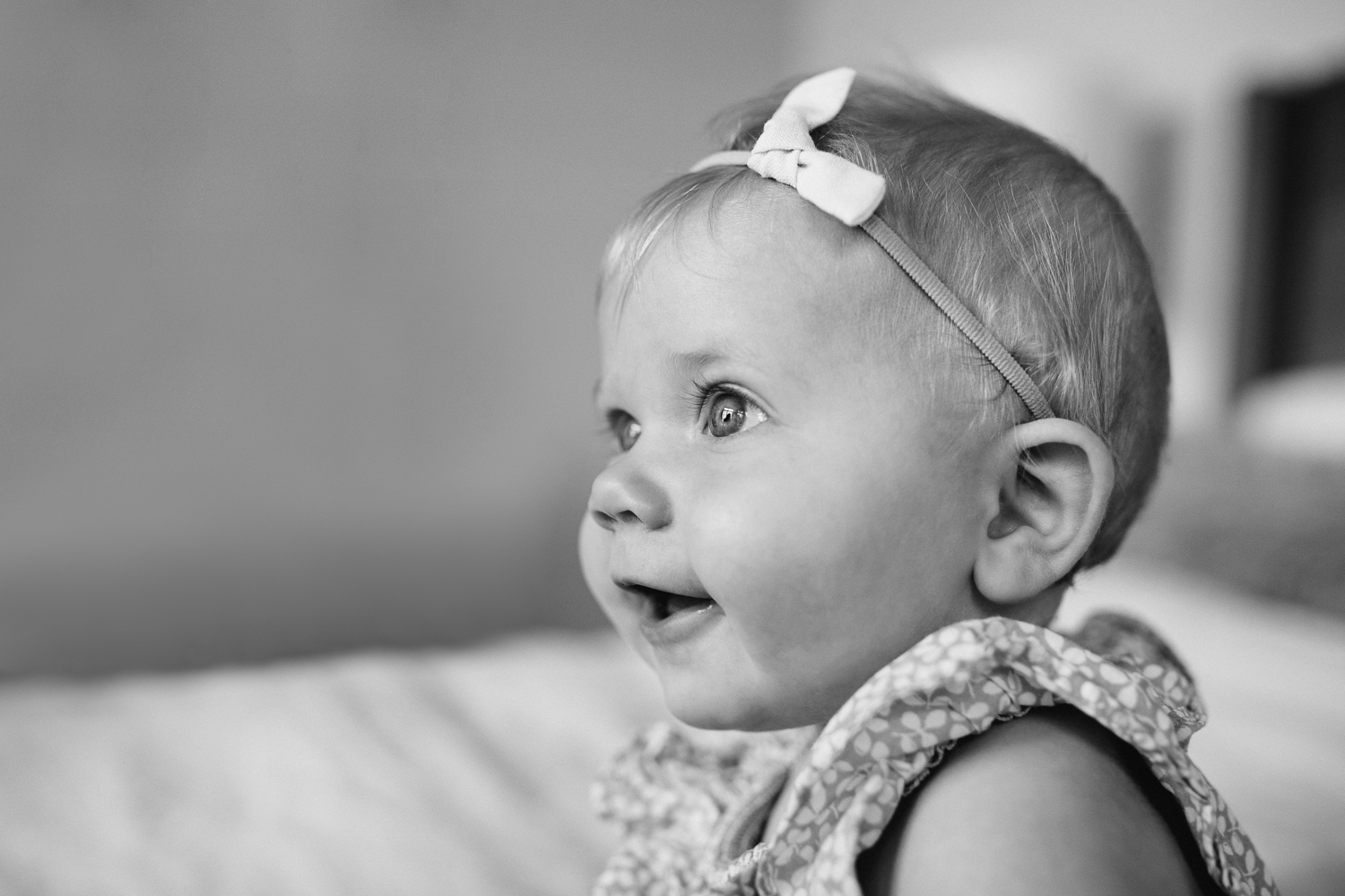 6 month old baby girl with blonde hair and blue eyes sitting on bed - Newmarket In-home Family Photos