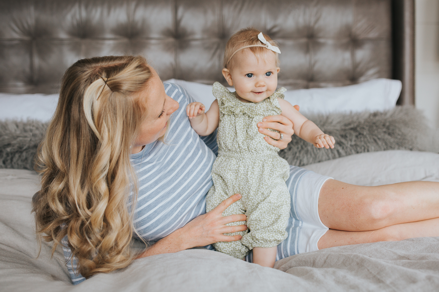 mom and 6 month old baby girl lying on bed, mother looking at daughter - Newmarket Lifestyle Family Photos