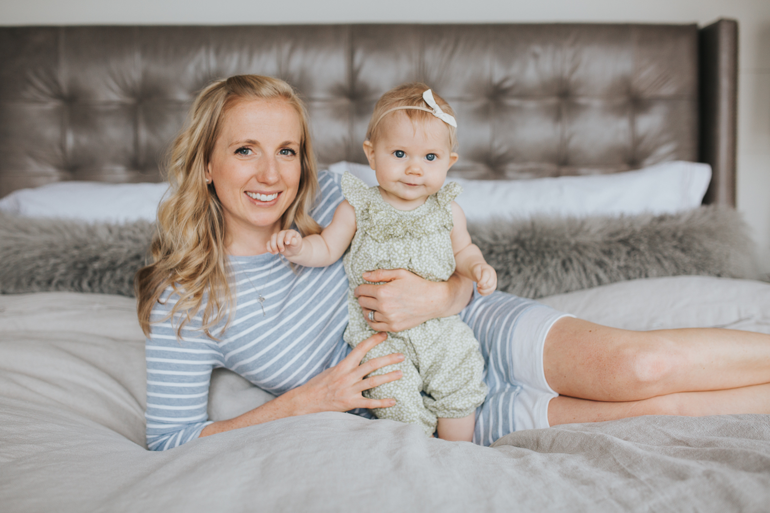 mom and 6 month old baby girl lying on bed looking at camera - Stouffville Lifestyle Family Photos