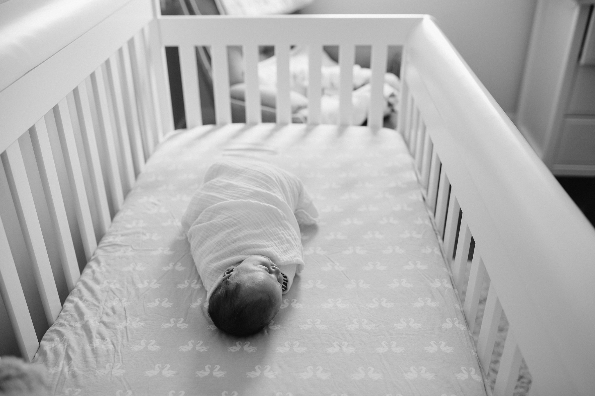 4 week old baby girl in white swaddle sleeping in crib - Stouffville Lifestyle Photography