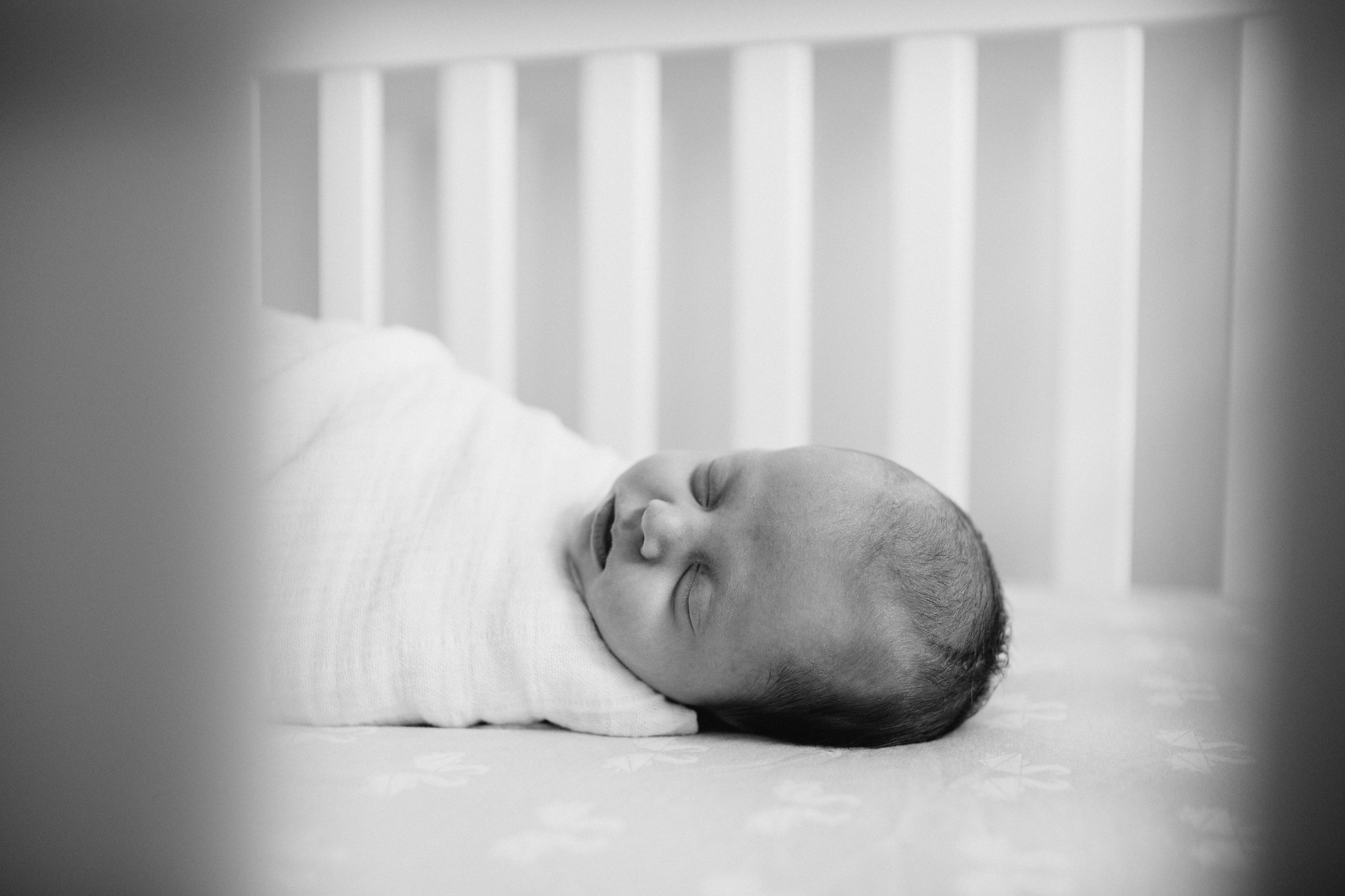 4 week old baby girl in white swaddle sleeping in crib - Markham Lifestyle Photography