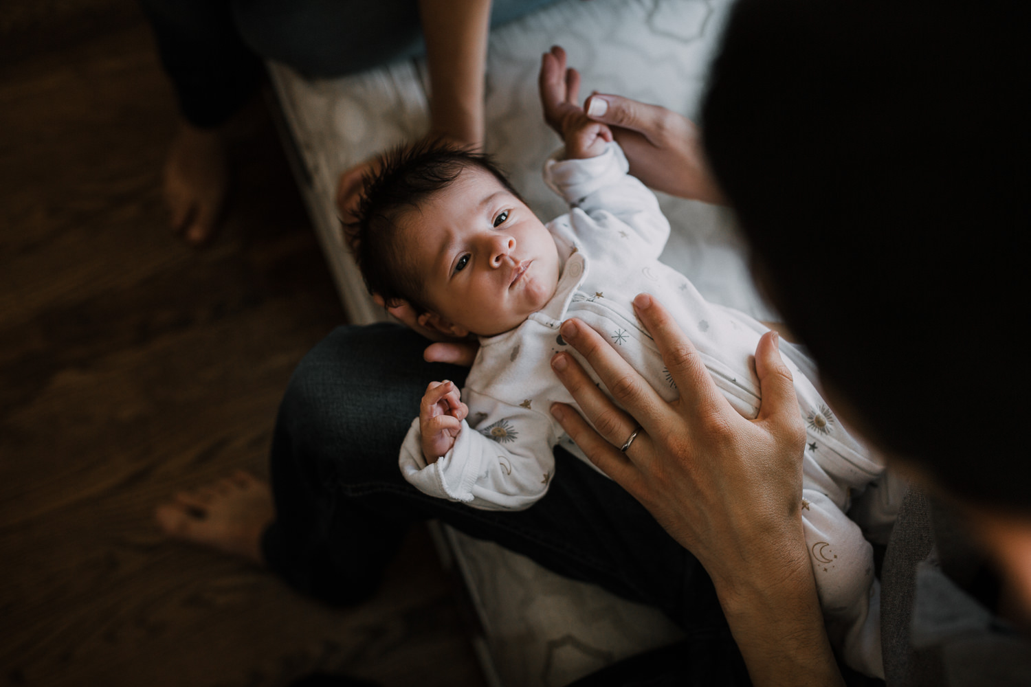 10 day old baby girl looking up at dad while lying in his arms - Barrie In-Home Photos