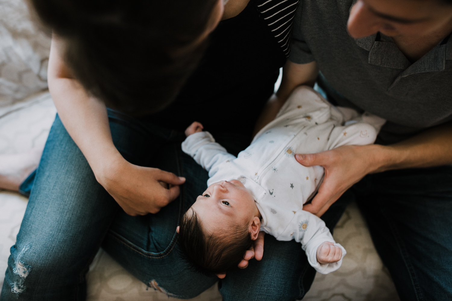 10 day old baby girl lying awake in mom and dad's laps - Newmarket Lifestyle Photos