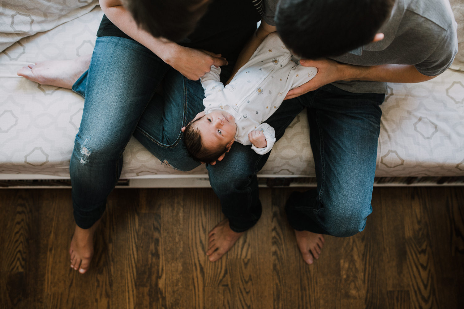 10 day old baby girl lying awake in mom and dad's laps, shot from above - Barrie Lifestyle Photos