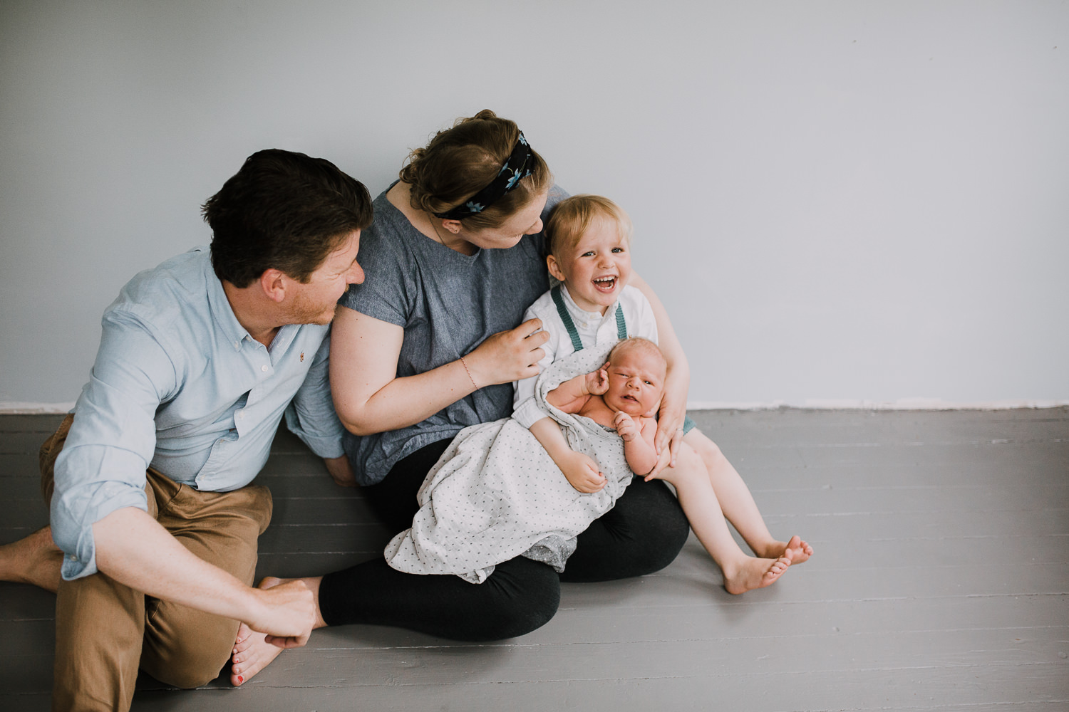 family of four sitting on ground, 2 year old toddler girl holds 10 day old baby boy - Markham Lifestyle Family Photography