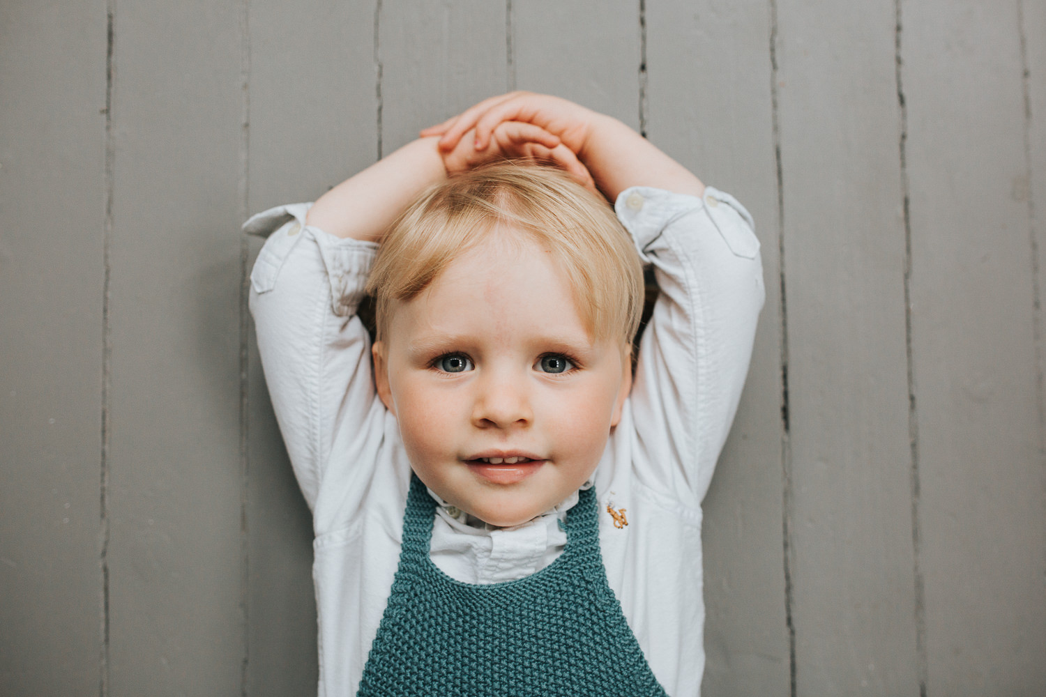 2 year old toddler girl with blonde hair and blue eyes lying on floor looking at camera - Barrie Lifestyle Family Photography