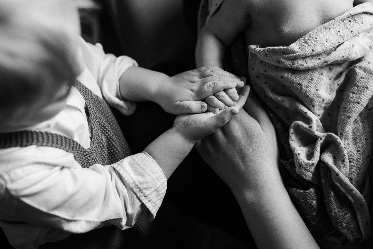 2 year old toddler girl holding 10 day old baby brother's hand - Newmarket In-Home Family Photos