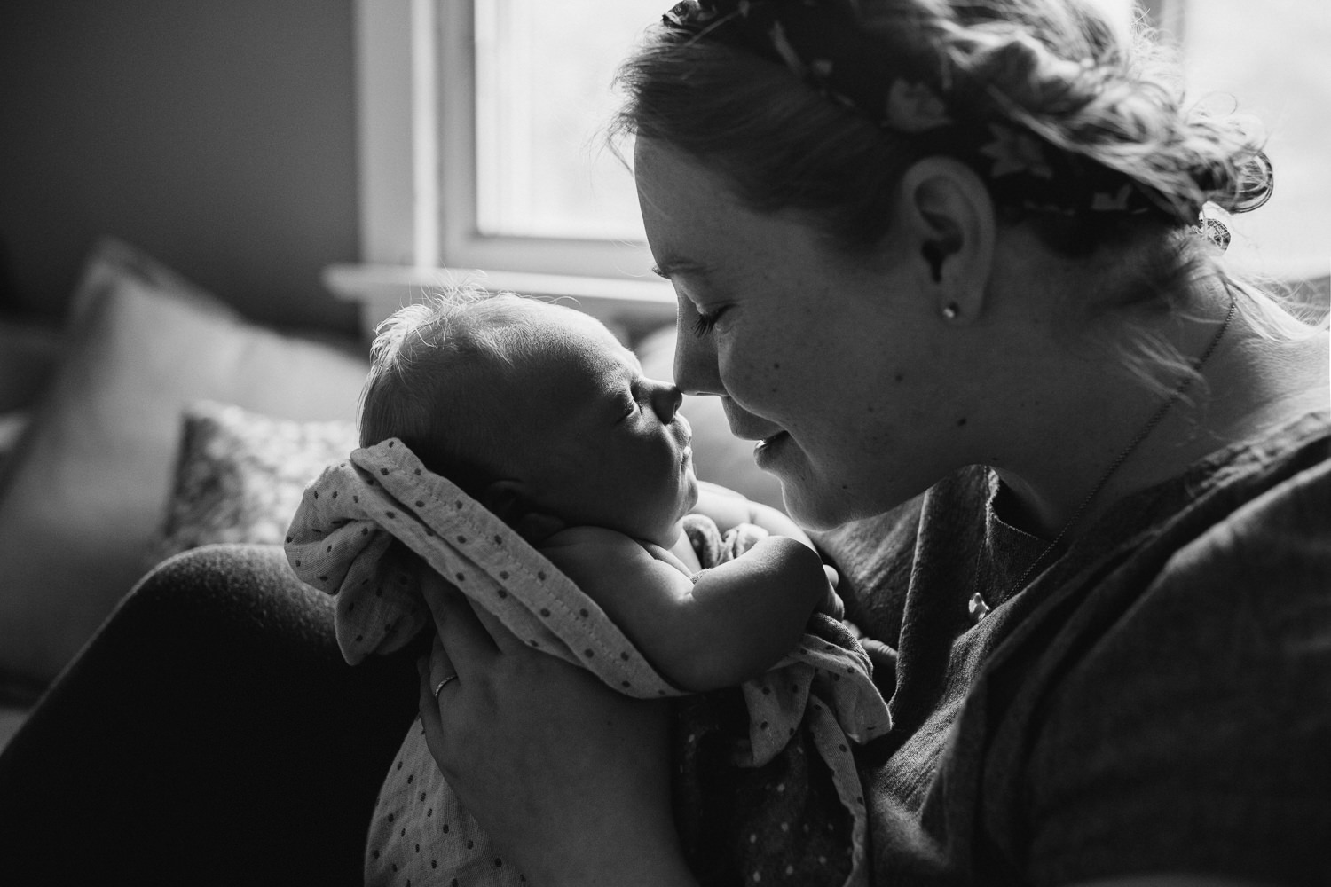 mom sits on couch with 10 day old baby boy, nose-to-nose - Barrie In-Home Family Photos
