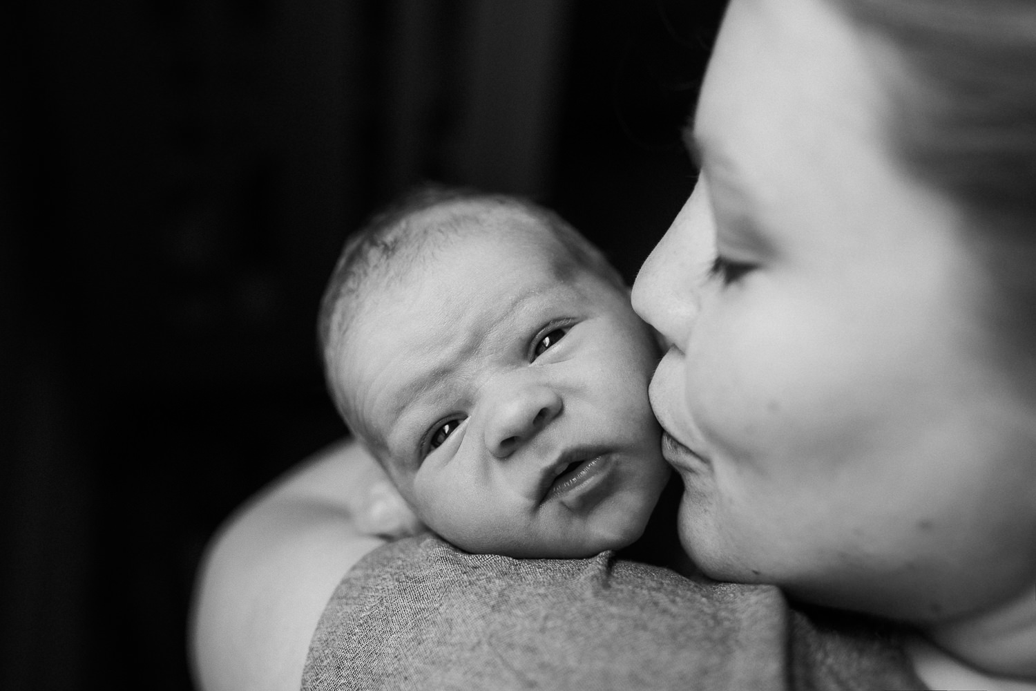 mom kissing 10 day old baby boy's cheek as he lies on her shoulder - Markham Lifestyle Family Photos