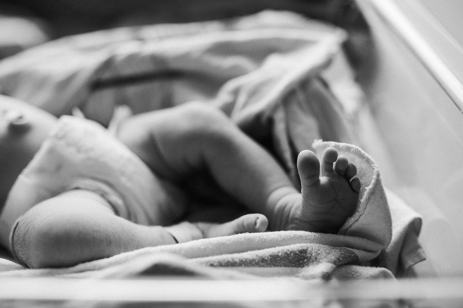 1 day old baby girl lying in diaper in hospital bassinet, close up of feet - Stouffville Fresh 48 Photography 