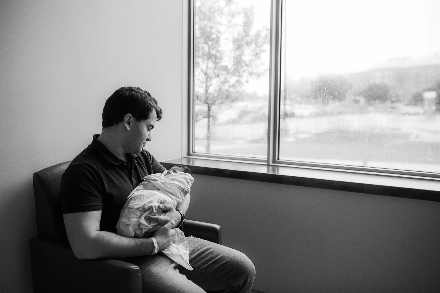 new dad sits in chair holding 1 day old baby girl swaddled in hospital blanket - Stouffville Fresh 48 Photos