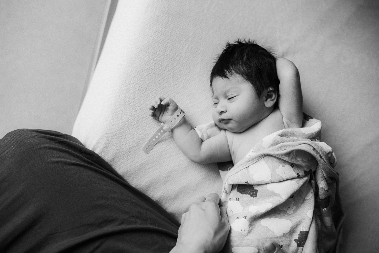 1 day old baby girl with lots of dark hair in swaddle lying on hospital bed - Barrie Fresh 48 Photography