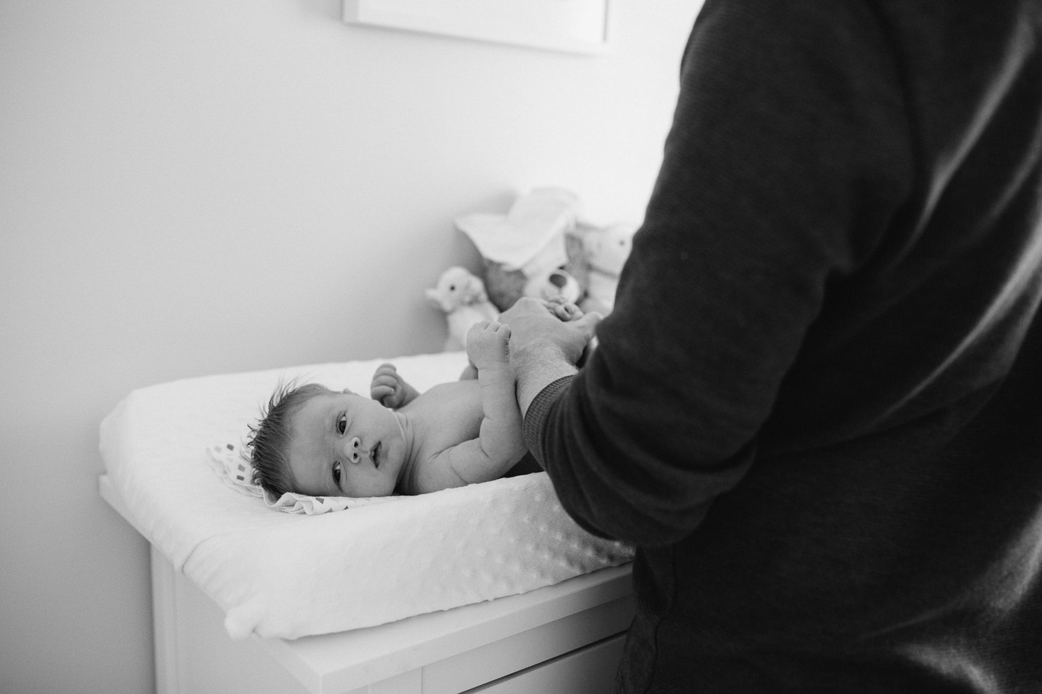 2 week old baby girl on change table while dad changes diaper - Newmarket Lifestyle Photos