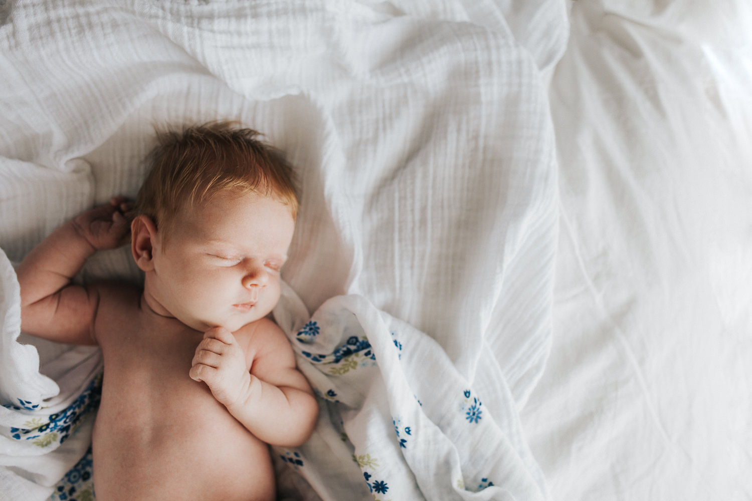 2 week old baby girl with red hair asleep on bed in diaper - Barrie Lifestyle Photography