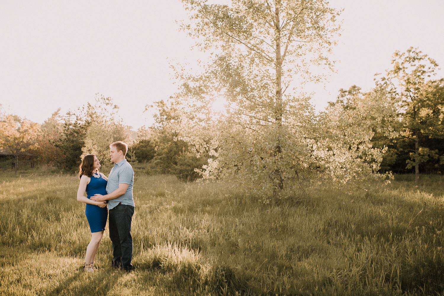  father-to-be and pregnant brunette wife in golden field at sunset - Barrie Lifestyle Photos