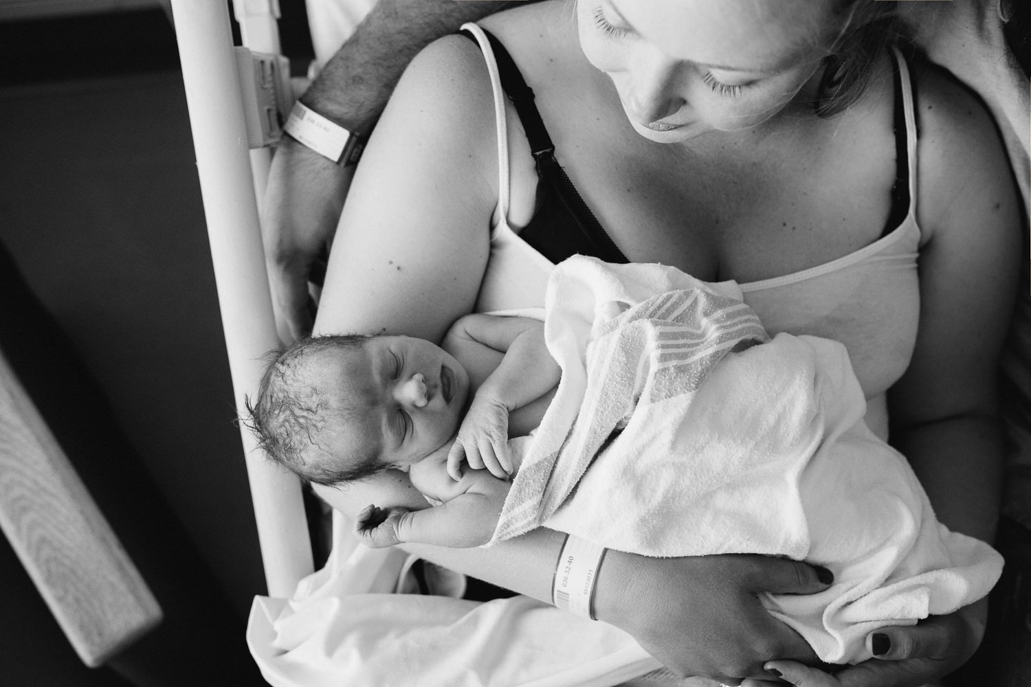 first time mom sitting in hospital bed holding 10 hour old baby boy - Newmarket In-Hospital Photos