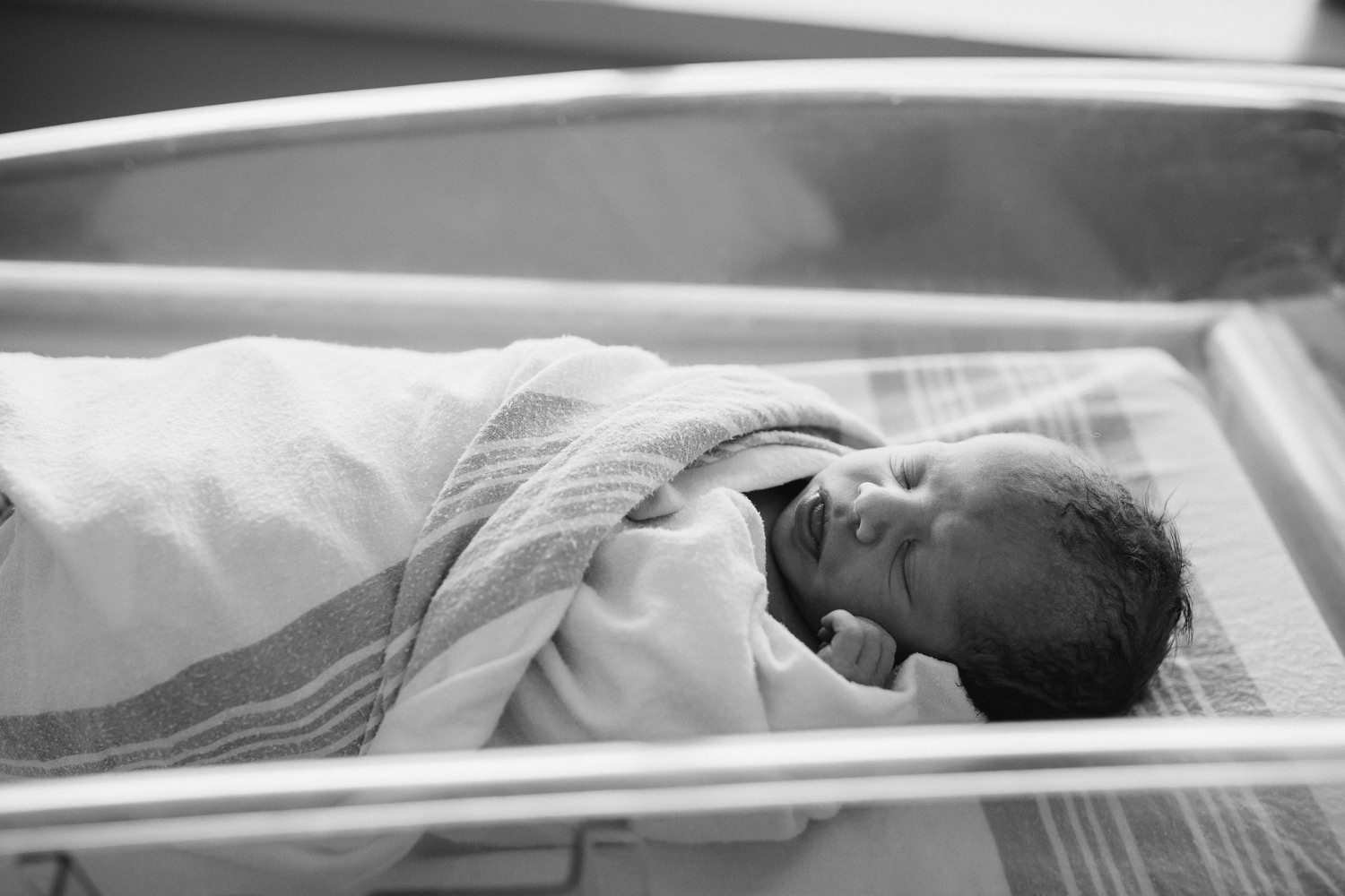 10 hour old baby boy in swaddle sleeping in hospital bassinet - Stouffville Fresh 48 Photography