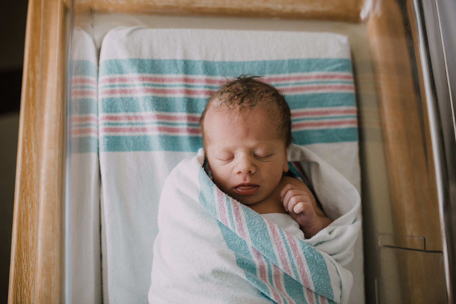 10 hour old baby boy in swaddle sleeping in hospital bassinet - Newmarket Fresh 48 Photography