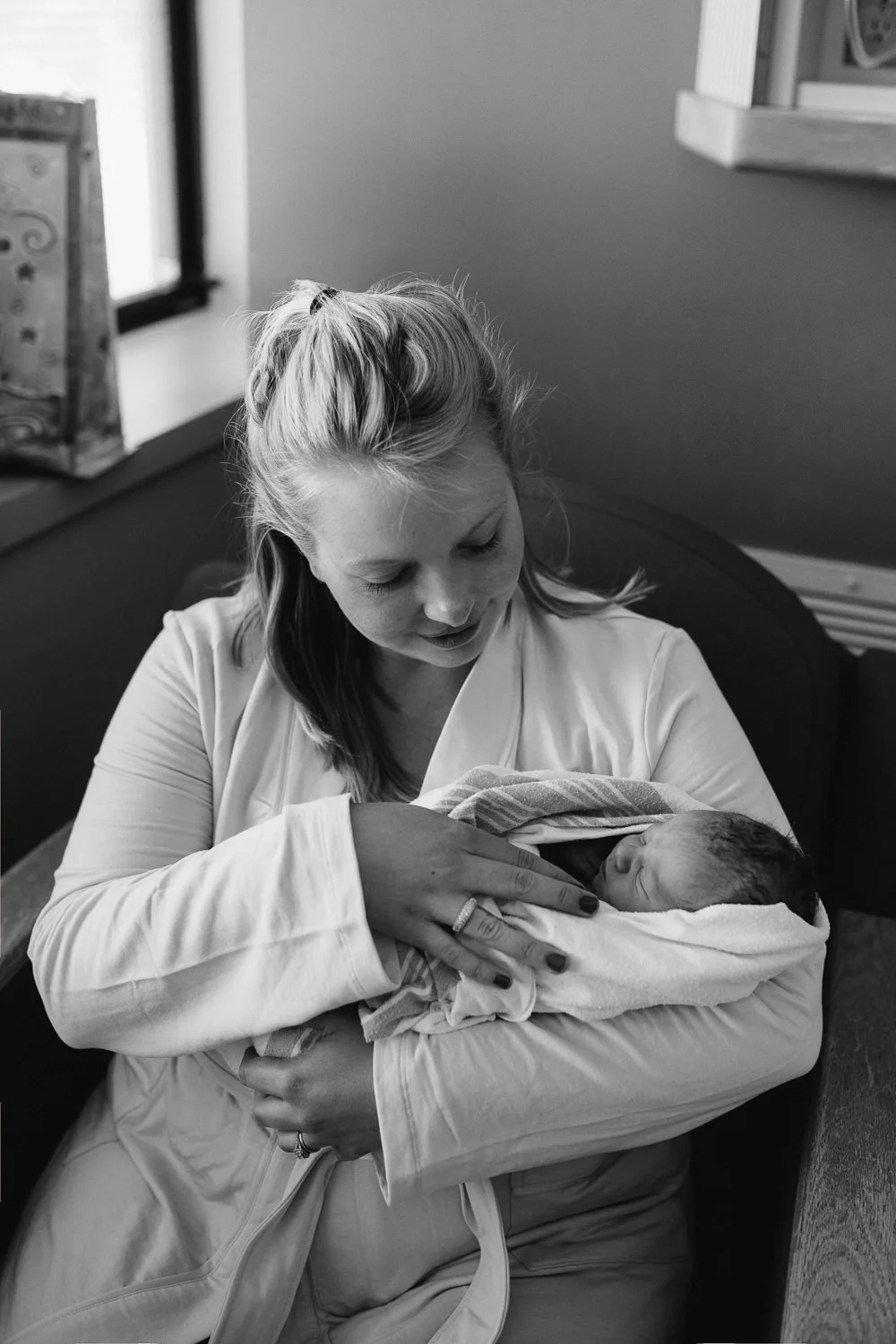 new mother sitting in hospital chair holding swaddled 10 hour old baby boy - Markham In-Hospital Photos