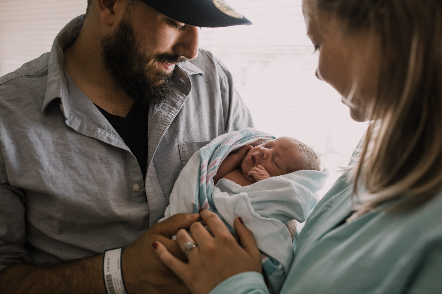 first time parents standing in hospital room holding and looking at 10 hour old baby boy - Stouffville Fresh 48 Photos