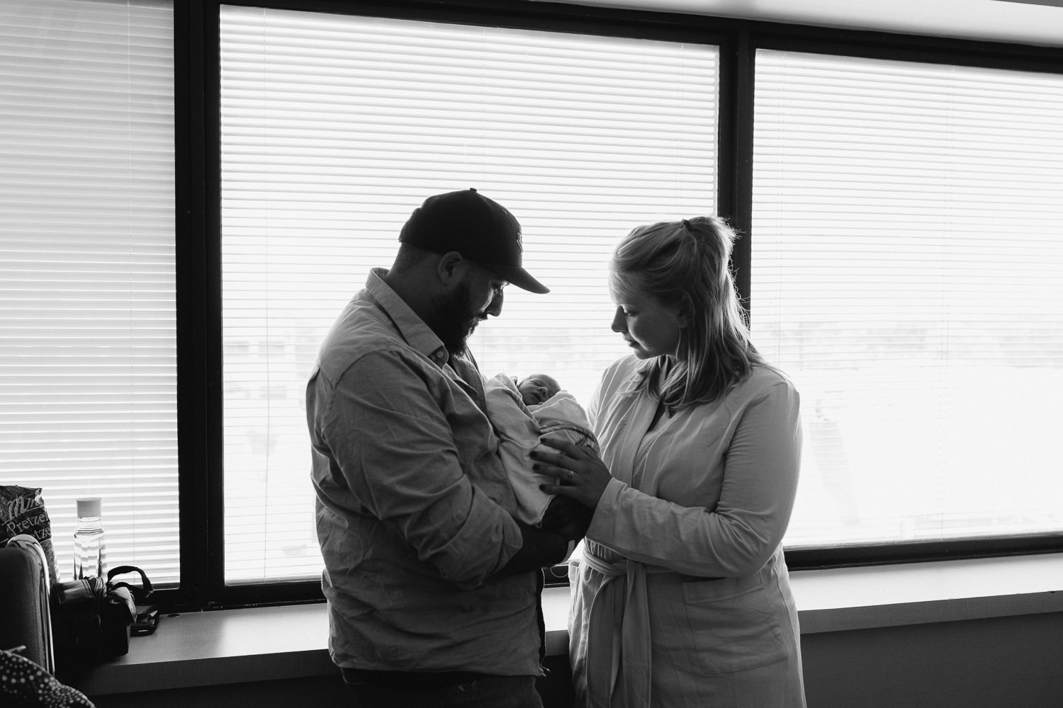 first time parents standing in hospital room holding and looking at 10 hour old baby boy - Barrie Fresh 48 Photos