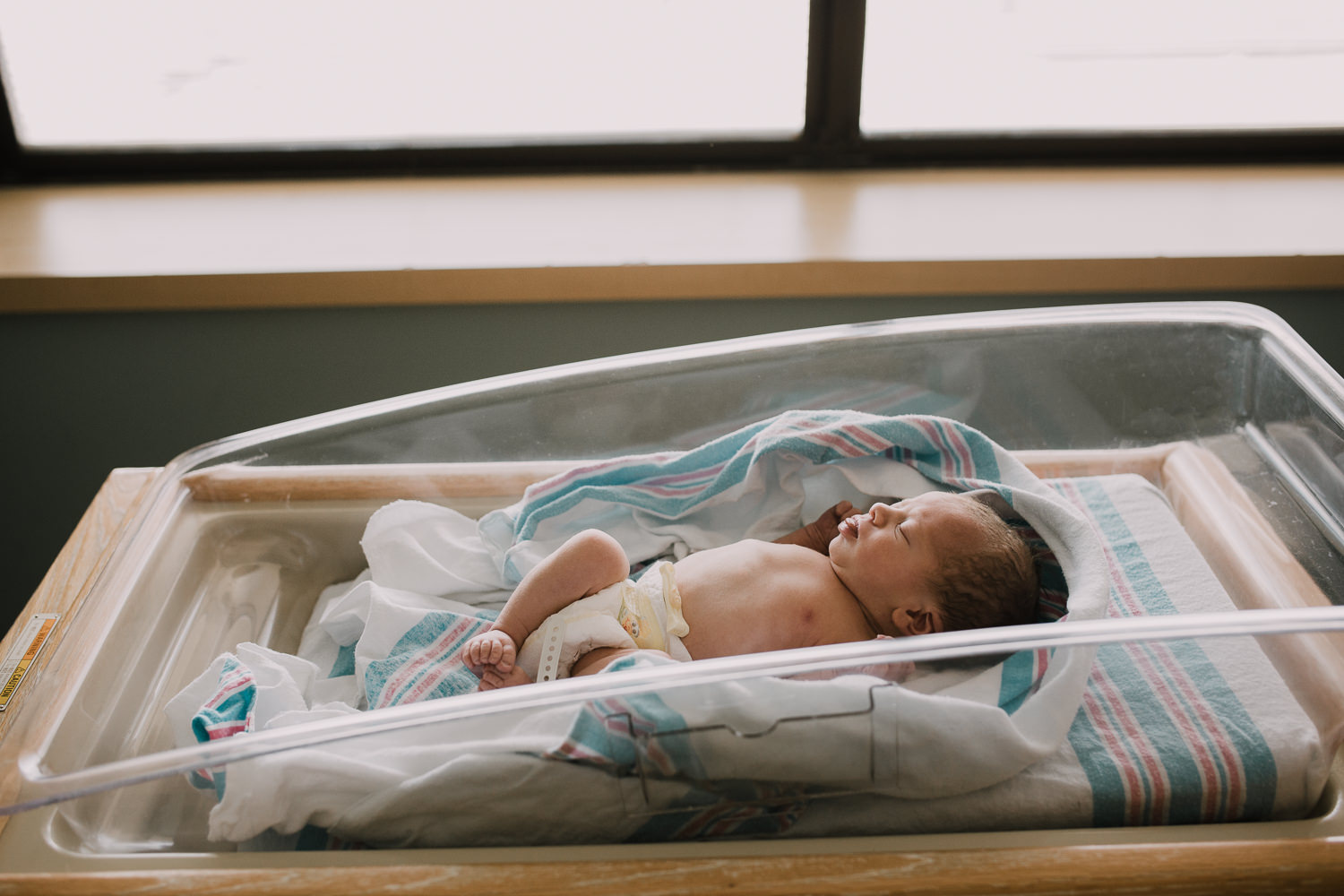 10 hour old baby boy in diaper sleeping in hospital bassinet - Newmarket Fresh 48 Photos