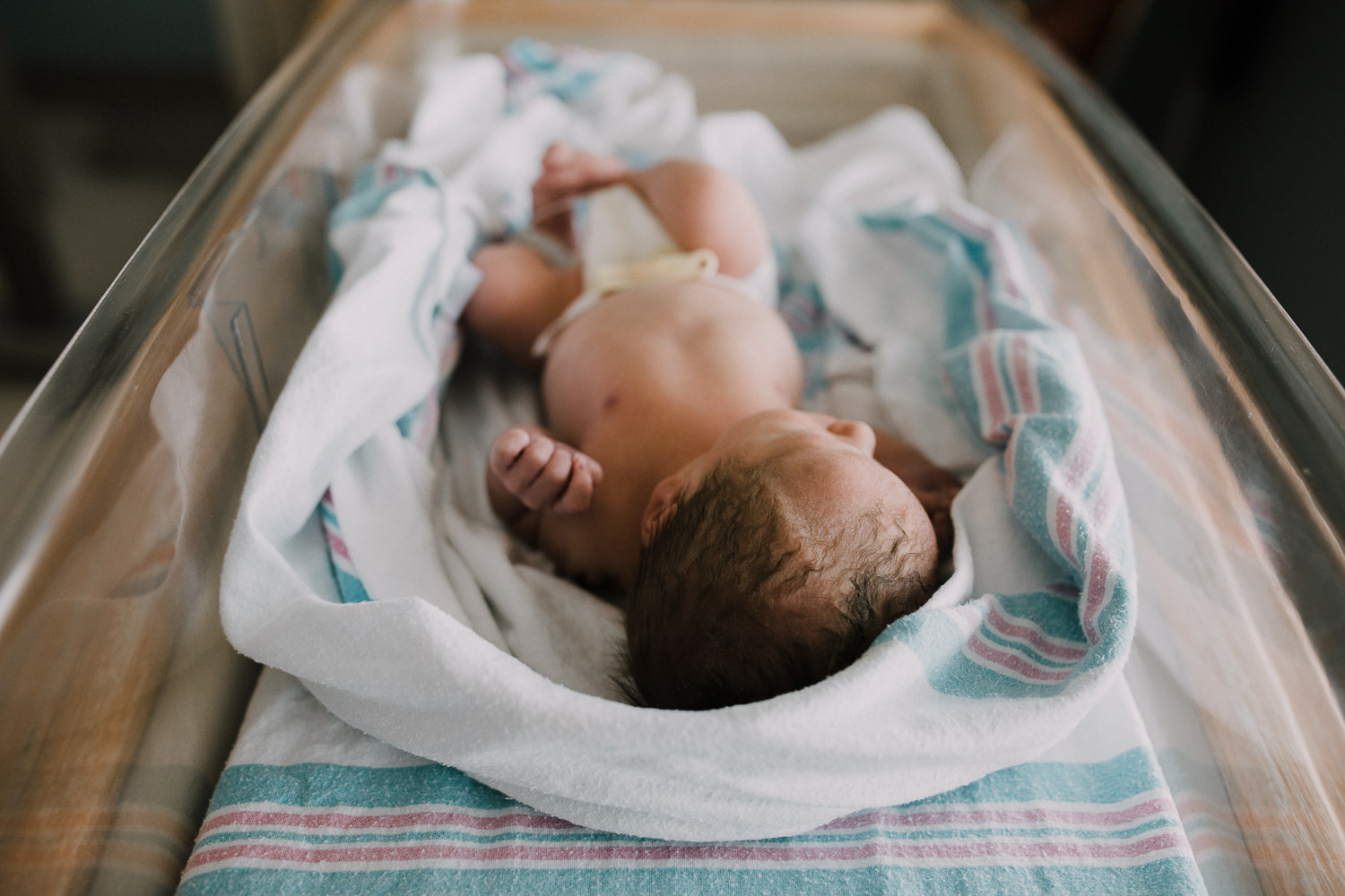 10 hour old baby boy in diaper sleeping in hospital bassinet - Barrie Fresh 48 Photography