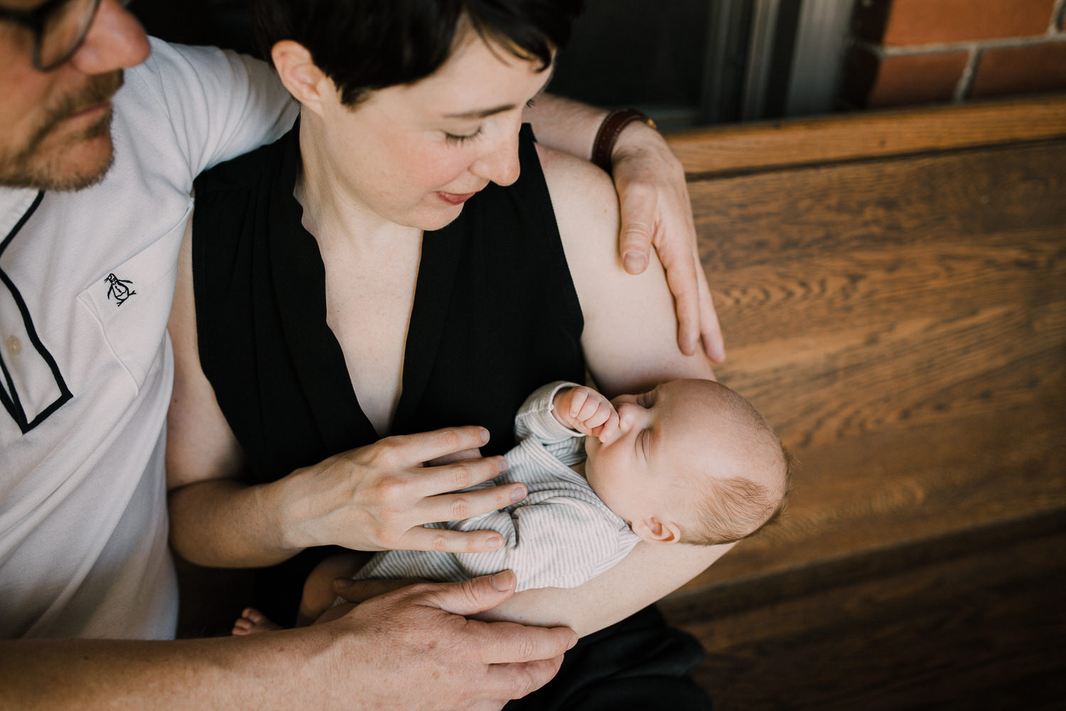 new parents sitting on front porch holding sleeping 2 week old baby boy - Newmarket In-Home Photos