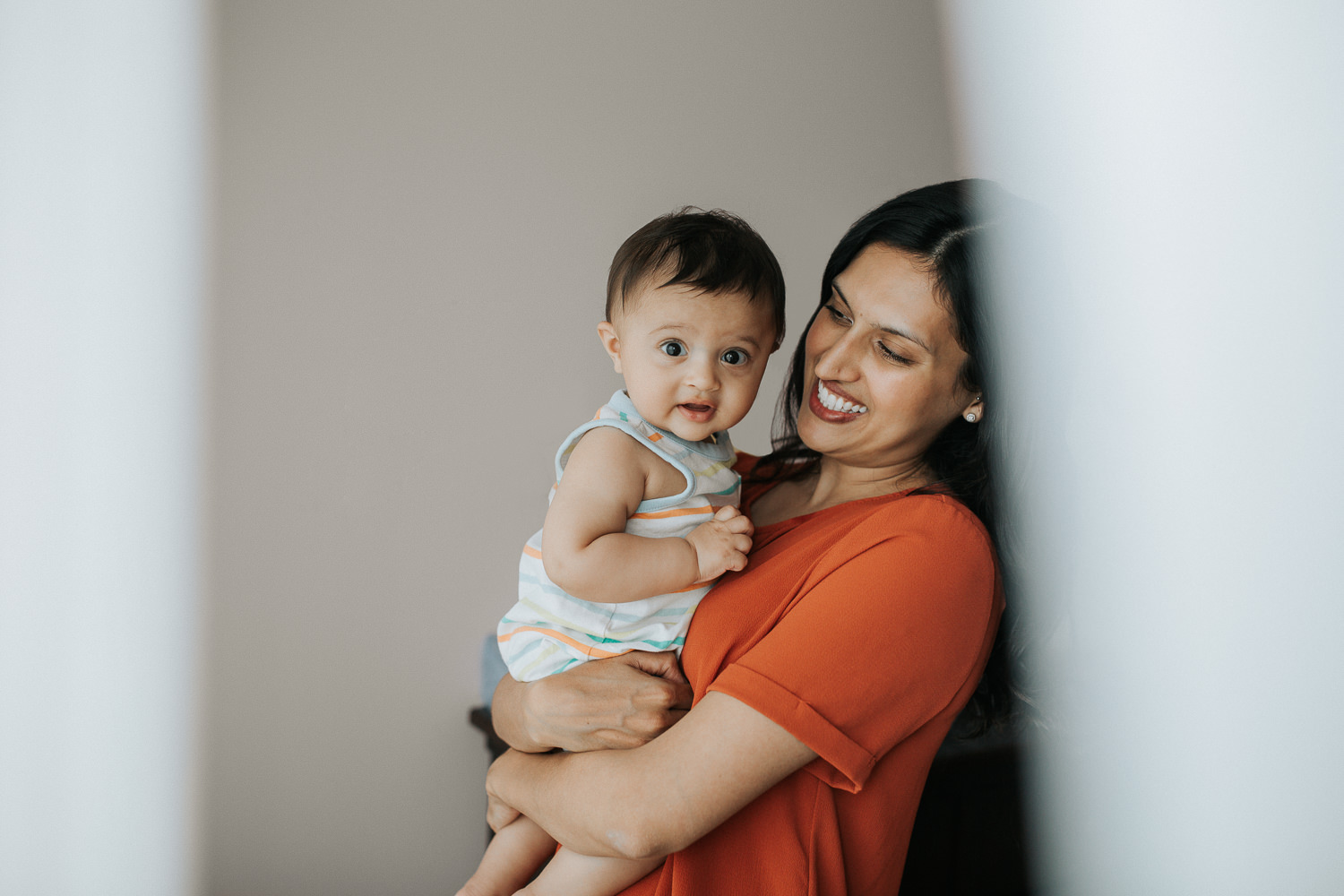 mom holding 8 month old baby son in her arms, boy looking at camera - Barrie In-Home Photos