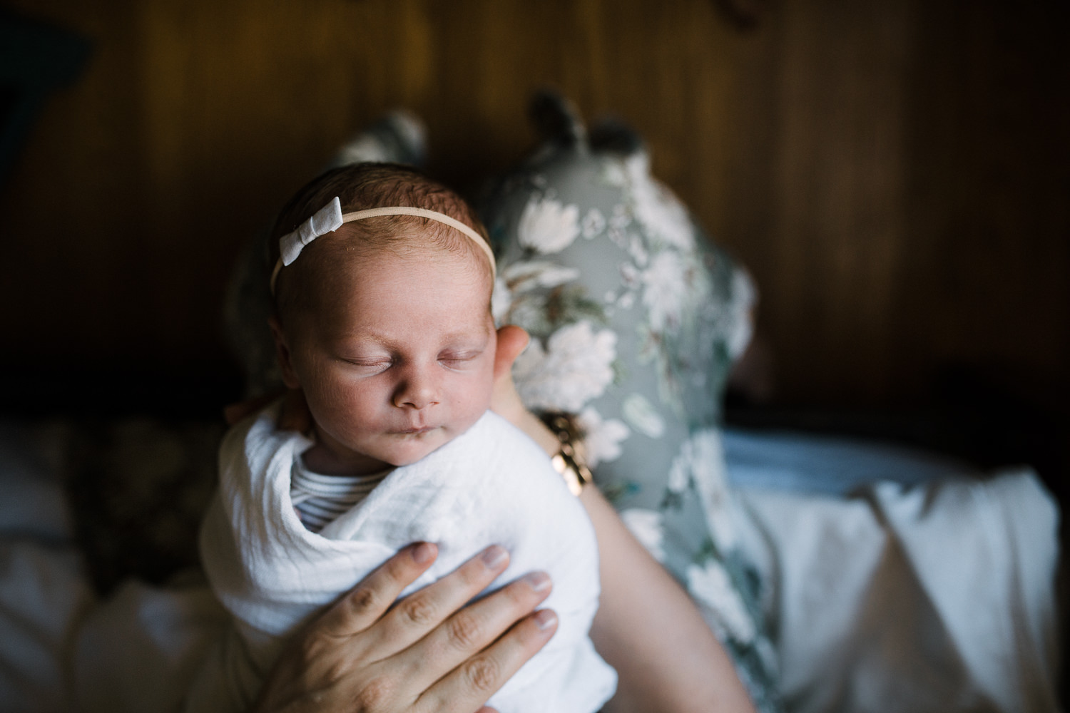 2 week old swaddled baby girl with headband on sleeping in mom's lap - Newmarket In-Home Photos 