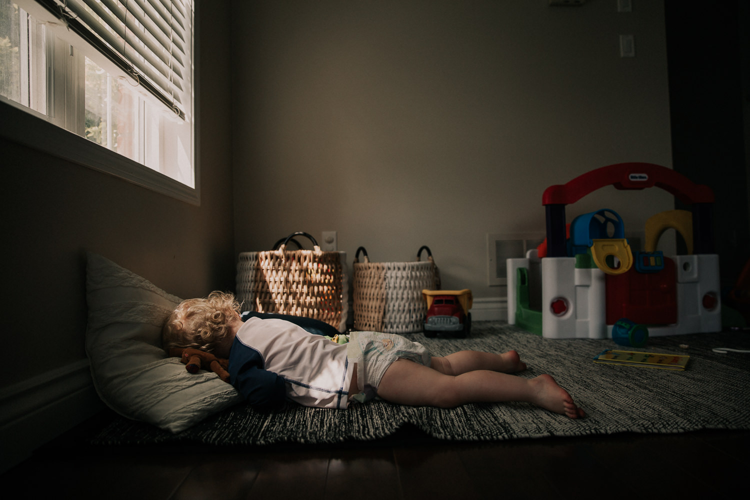 toddler boy in diaper sleeping on floor, face down - Stouffville Family Photographer