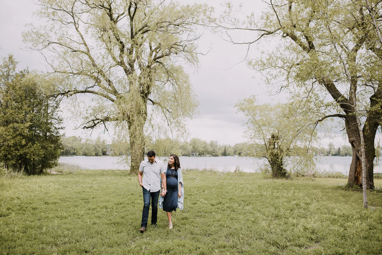 parents-to-be holding hands and walking away from the lake - Stouffville In-Home Photos