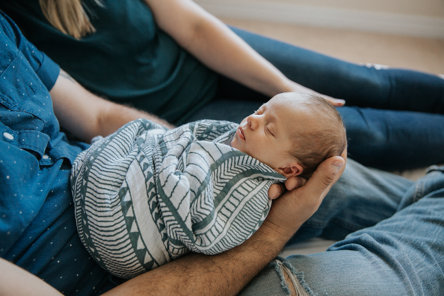 2 week old baby boy in swaddle, asleep in dad's arms - Newmarket Lifestyle Photos