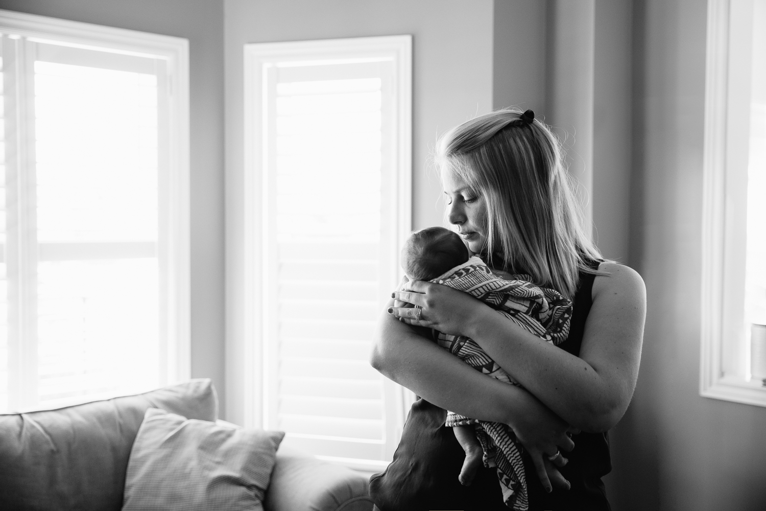 new mom standing in front of window rocking 2 week old baby boy to sleep - Stouffville Lifestyle Photography