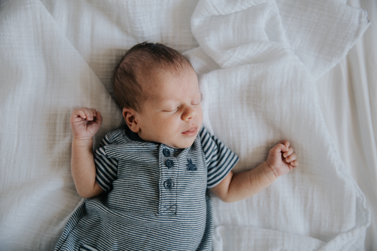 2 week old baby boy in blue outfit sleeping on bed - Newmarket In-Home Photos