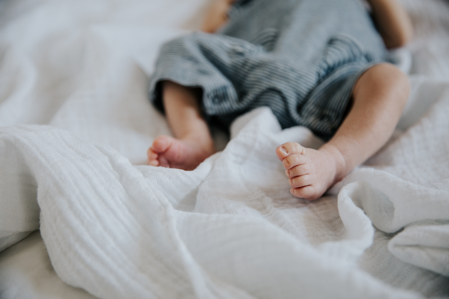 2 week old baby boy lying on bed, close up of feet - Barrie In-Home Photos