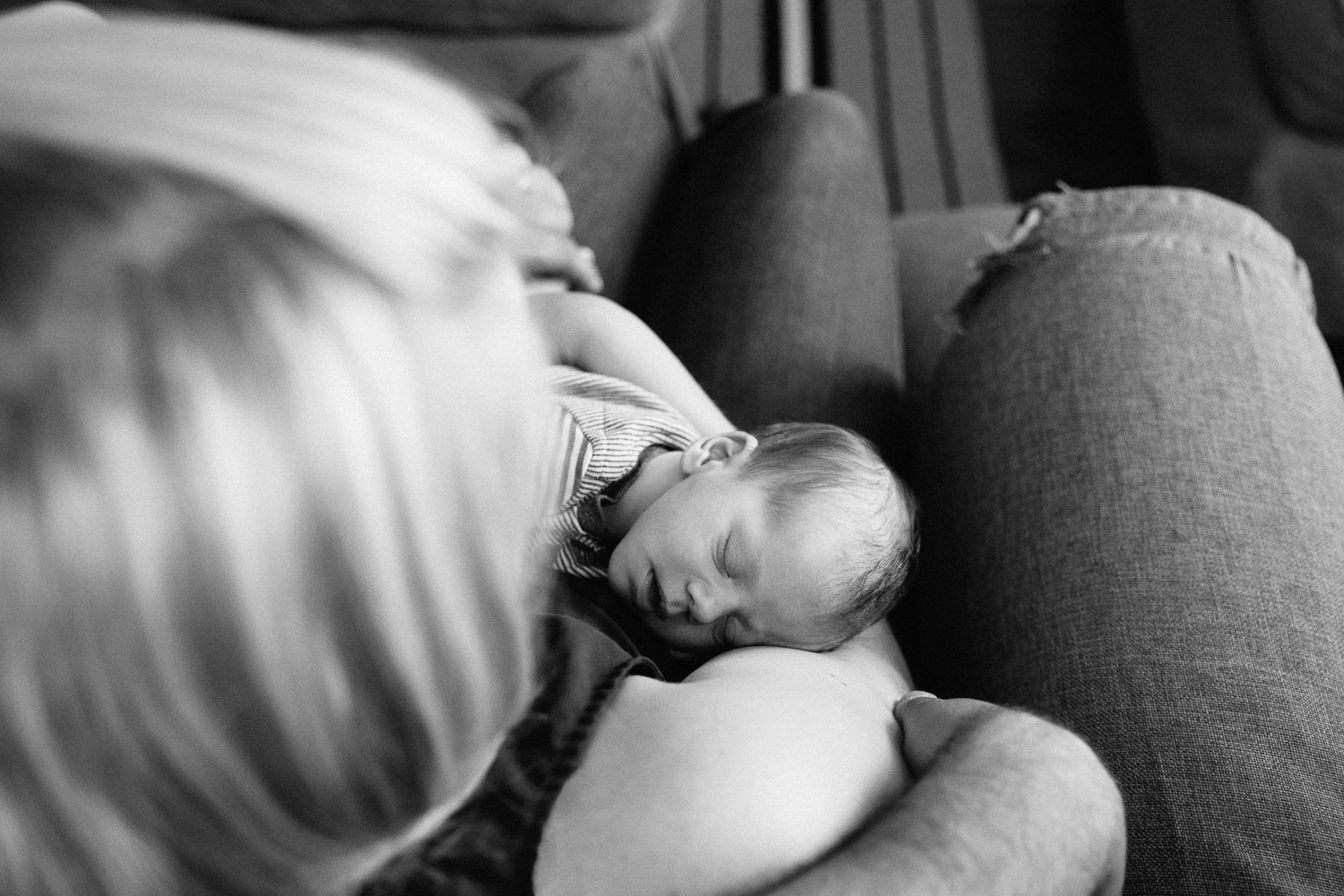 2 week old baby boy lying asleep in mother's arms - Newmarket In-Home Photography