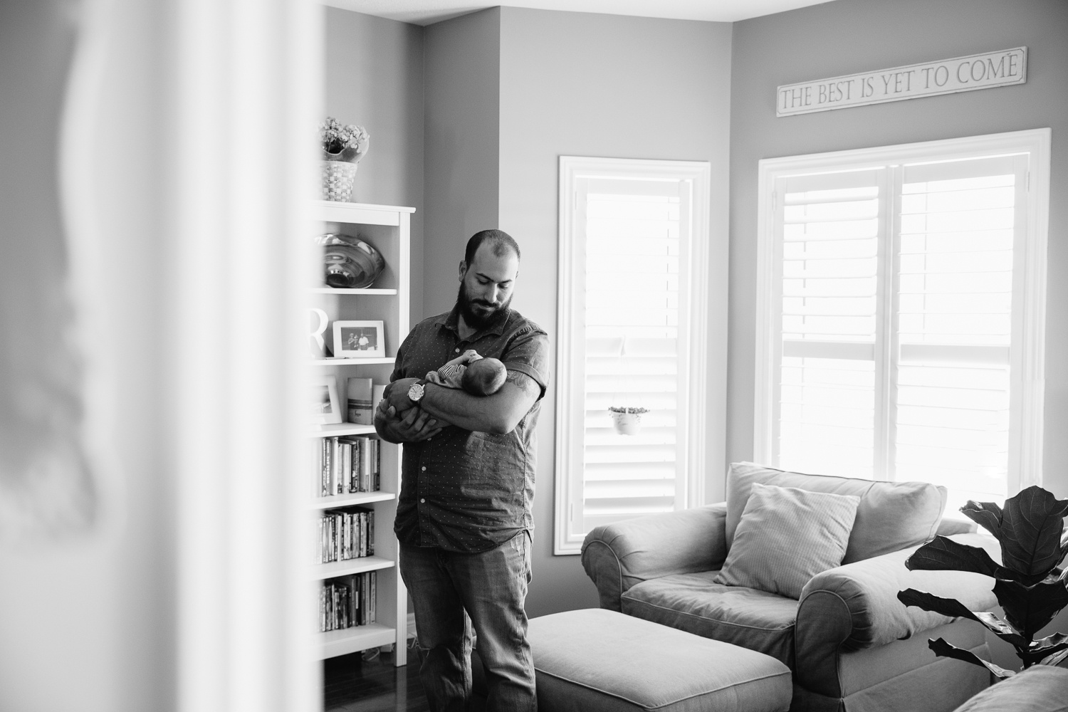 new dad standing in living room holding 2 week old baby son - Markham In-Home Photography