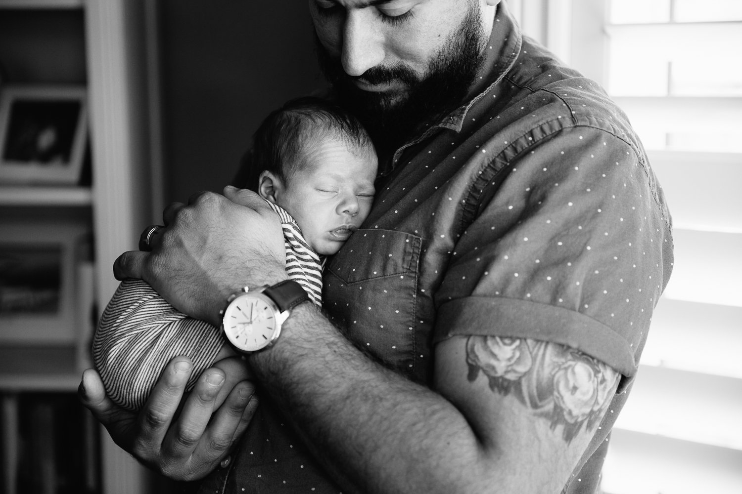 new father standing, snuggling sleeping 2 week old baby boy to his chest - Barrie In-Home Photography