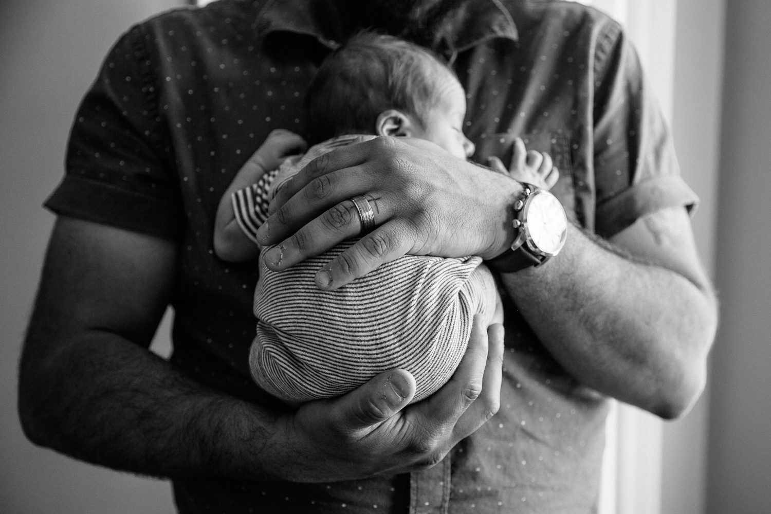 new father standing, snuggling sleeping 2 week old baby boy to his chest - Markham In-Home Photos