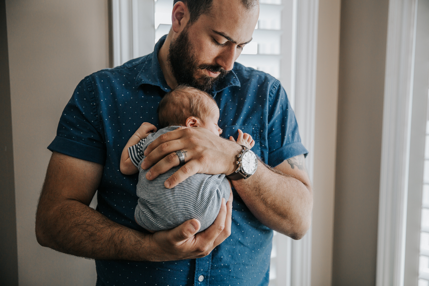 new father standing, snuggling sleeping 2 week old baby boy to his chest - Barrie In-Home Photos