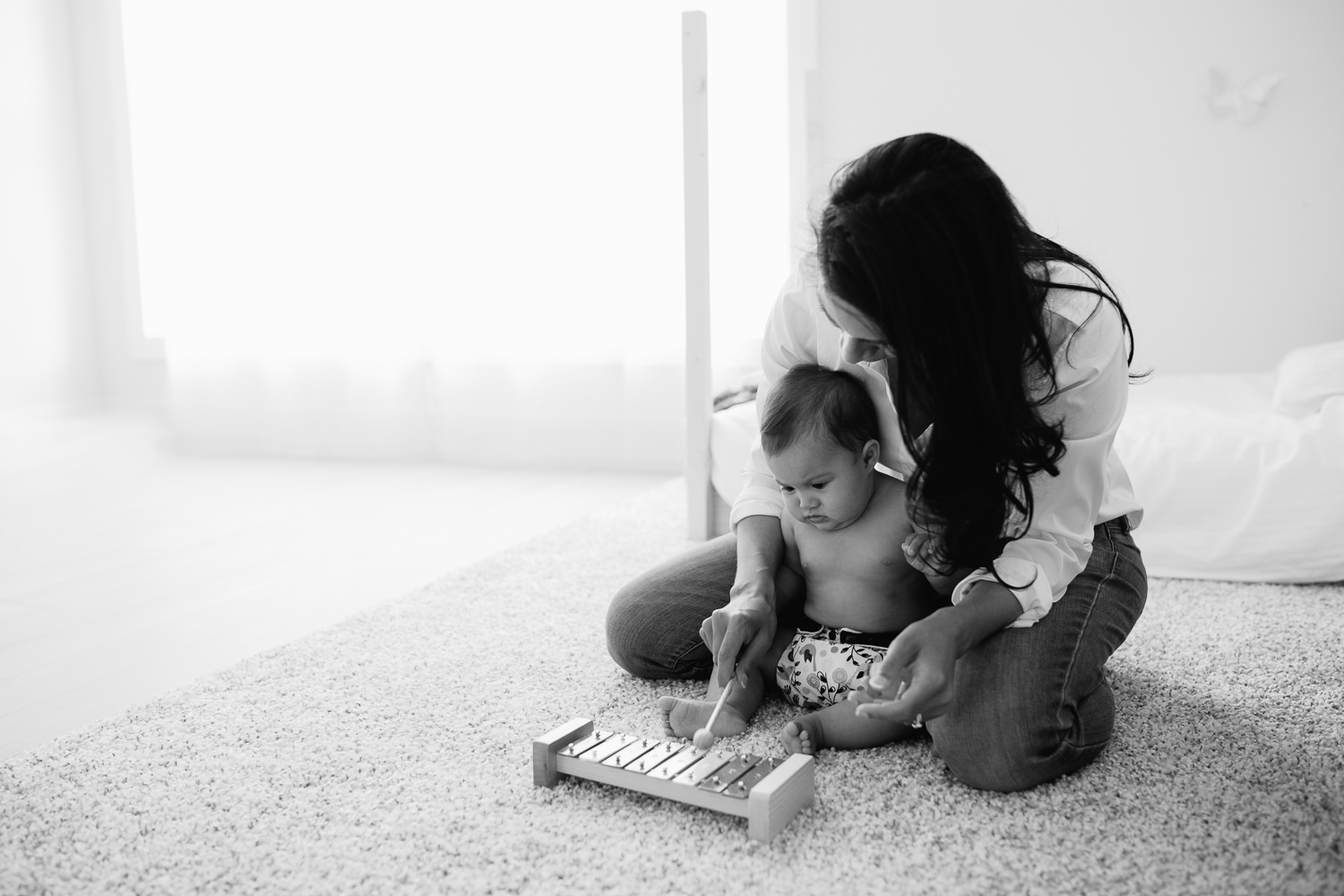 mother and 6 month old baby daughter sitting on floor playing with xylophone - Stouffville In-Home Photography