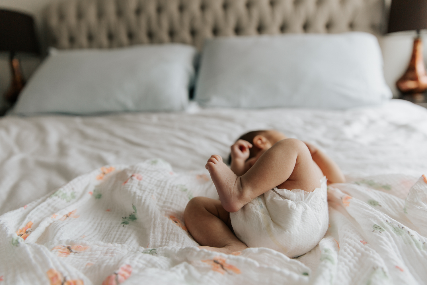 2 week old baby girl in diaper lying on bed, close up of feet - Markham In-Home Photos