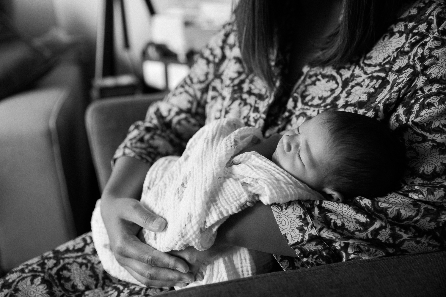 first time mother sitting on chair holding sleeping 2 week old baby girl - Markham Lifestyle Photography