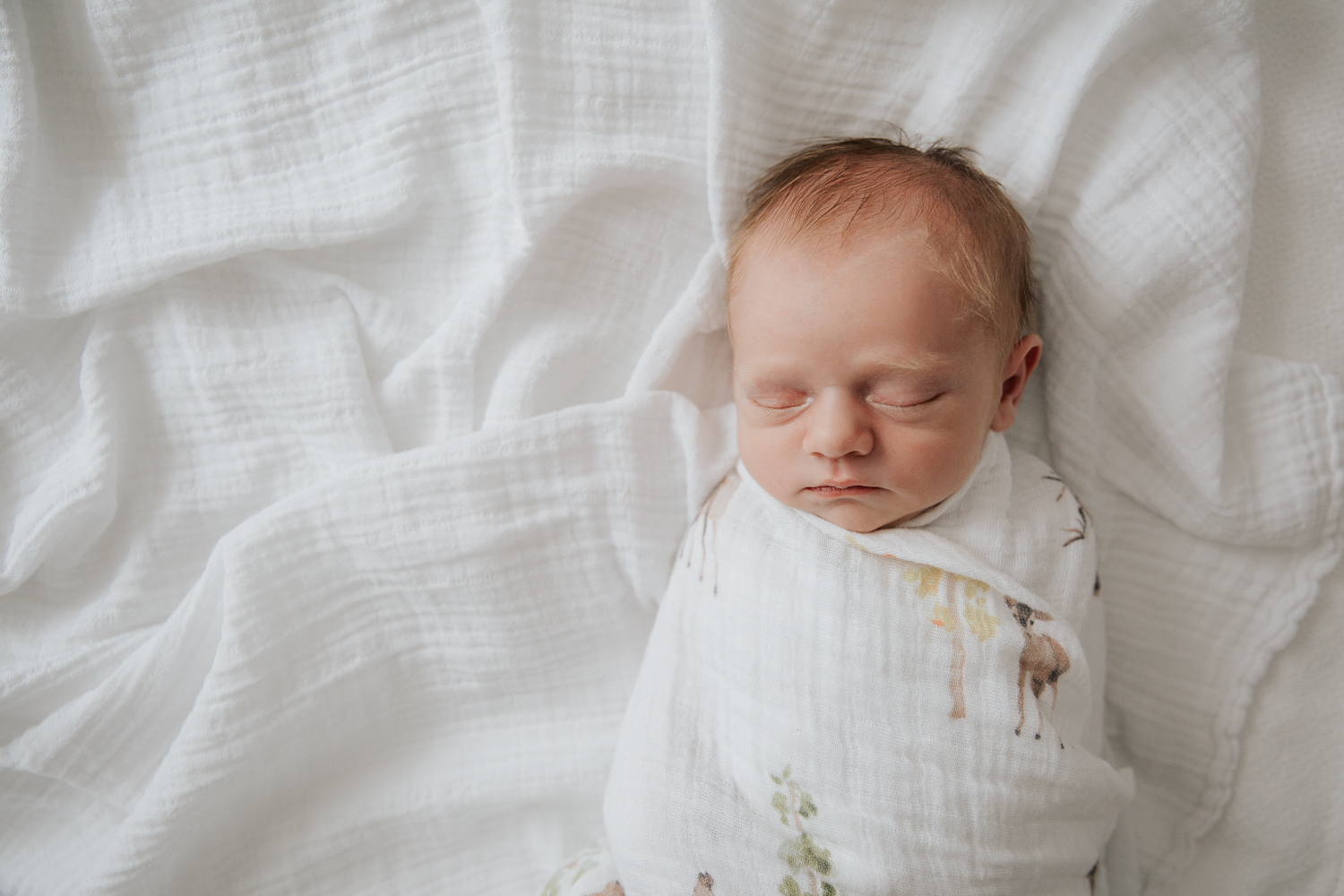3 week old swaddled baby boy with red hair sleeping on bed - Newmarket In-Home Photos
