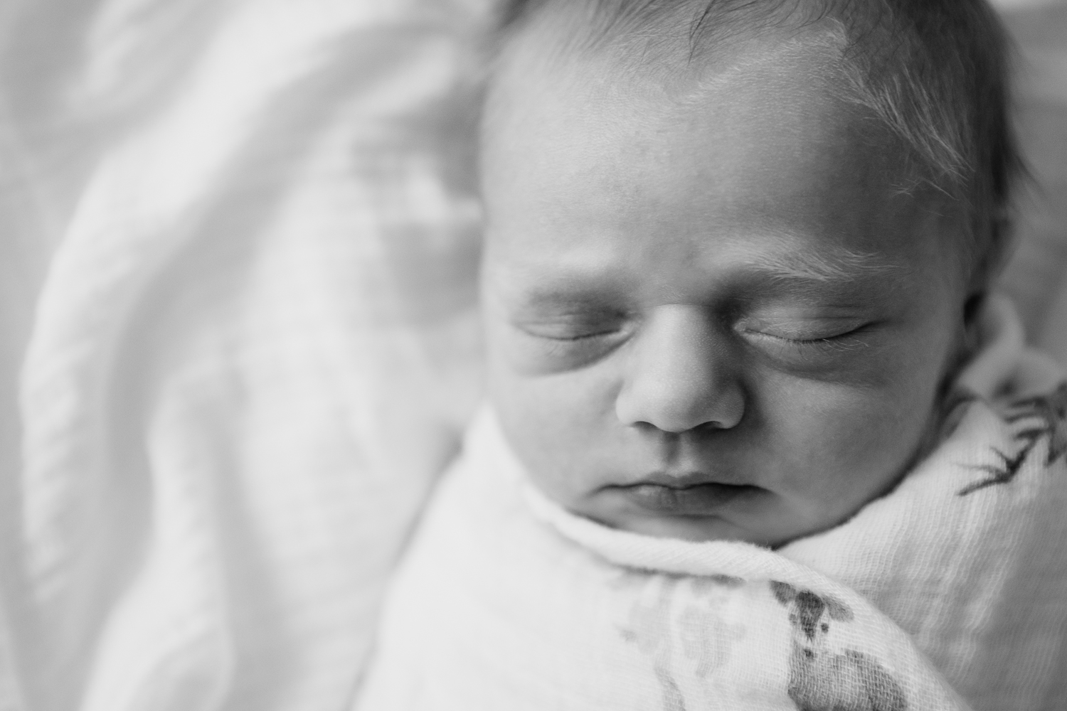 3 week old swaddled baby boy with red hair sleeping on bed, close up of face - GTA In-Home Photography