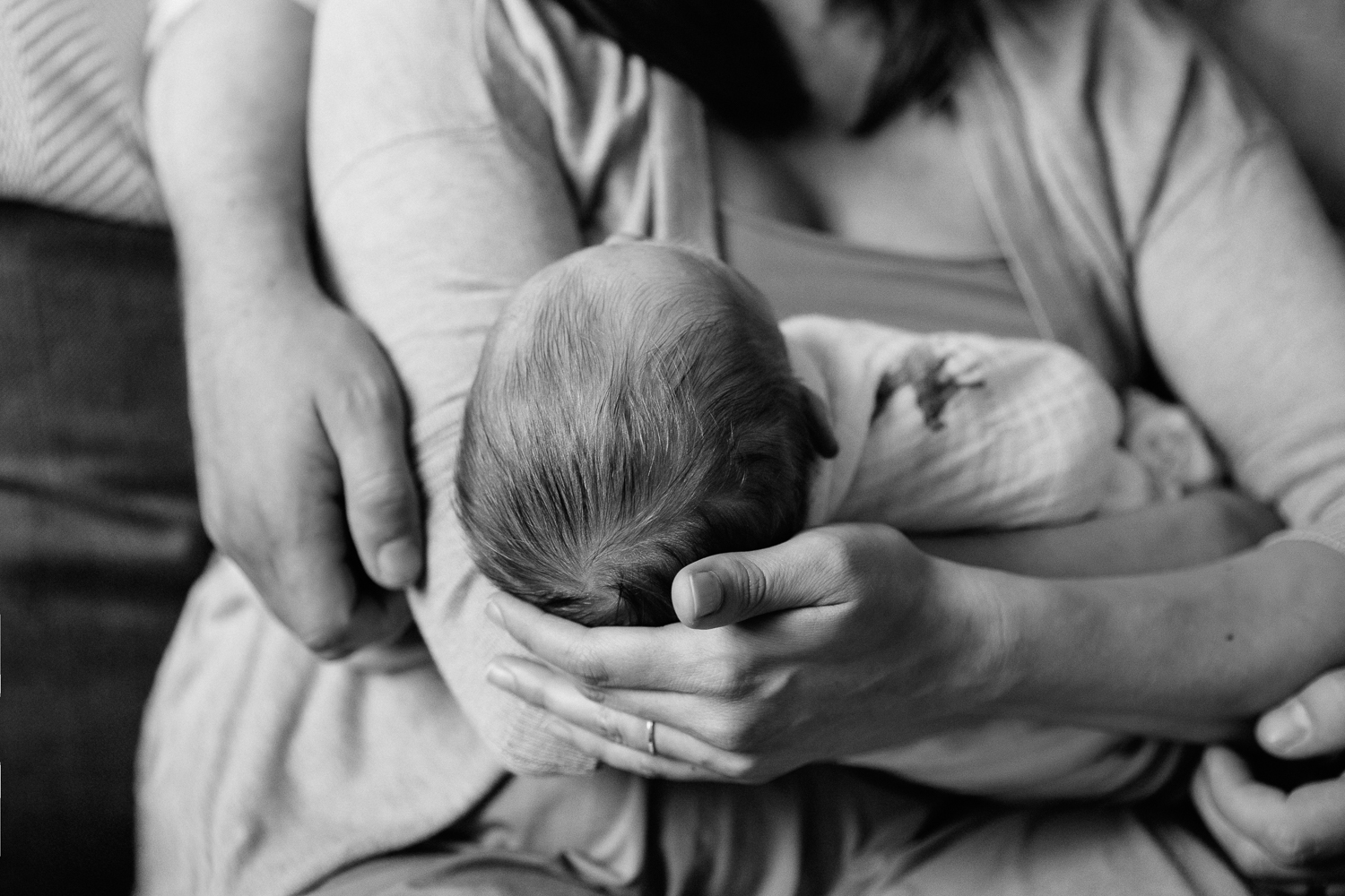 3 week old baby boy in white swaddle lying asleep in mom's arms - Barrie In-Home Photos