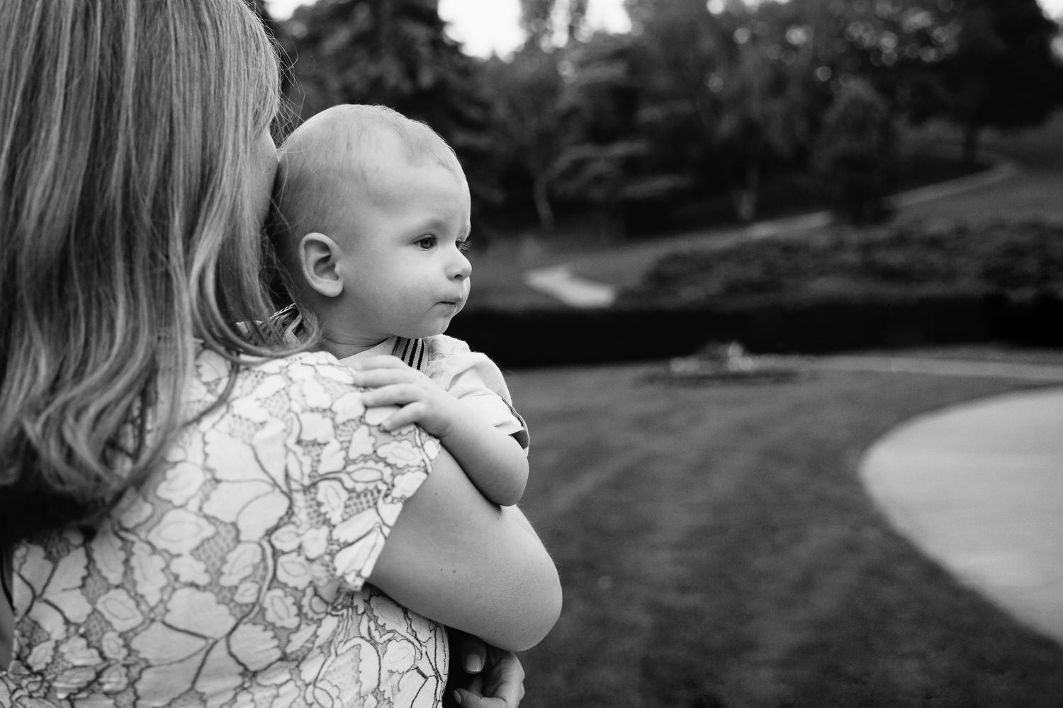 8 month old baby boy in mom's arms, hand on her shoulder looking tired off into the distance - York Region Lifestyle Photography